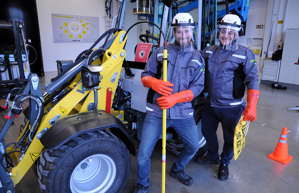 Helm, Handschuhe und Schutzstab. Im Umgang mit Hochvoltgeräten ist je nach Vorgaben der Hersteller Schutzausrüstung von großer Bedeutung.